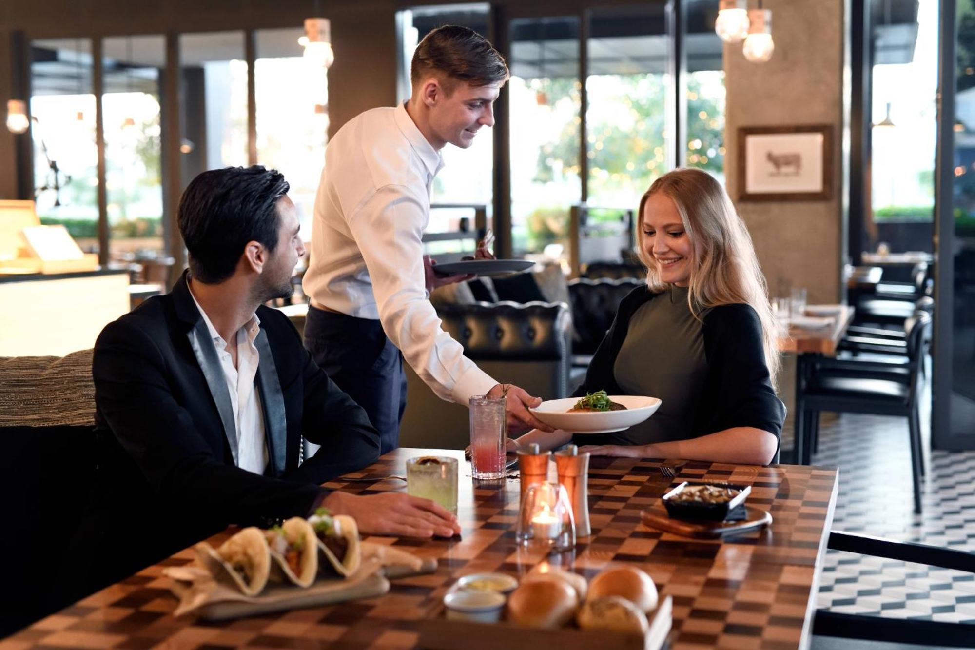 La Ville Hotel & Suites City Walk Dubai, Autograph Collection Bagian luar foto A waiter serving a couple